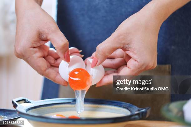 the woman's hands breaking the egg in a cup - home salted stock pictures, royalty-free photos & images