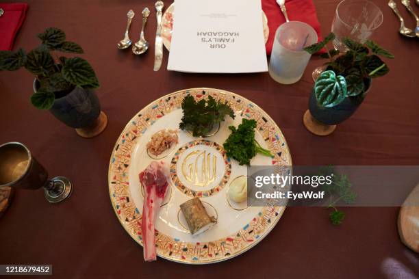 overhead shot of a table set set for passover with a seder plate in the center and a haggadah in the background - passover stock-fotos und bilder