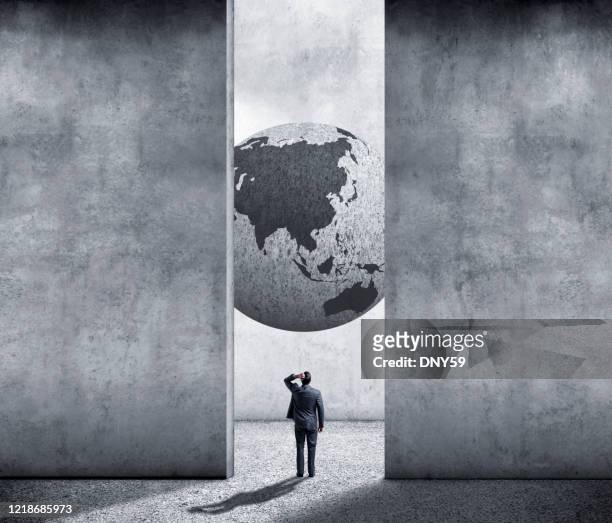 businessman looks up at globe showing asia - capitalism stock pictures, royalty-free photos & images