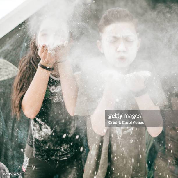 brother and sister playing with flour during lockdown - busy mum mess stock-fotos und bilder