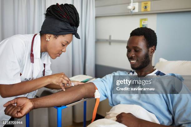 teenage african medical student drawing blood in hospital - blood donation imagens e fotografias de stock