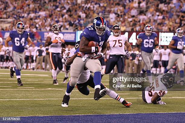 Brandon Jacobs of the New York Giants breaks the tackle of Chris Harris of the Chicago Bears and scores a touchdown during their pre season game on...