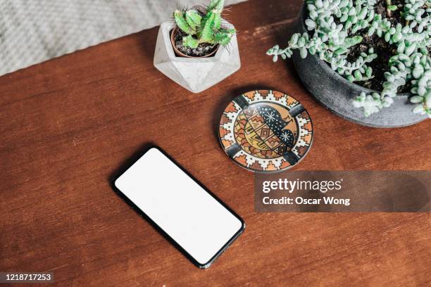 potted plants and smartphone on the coffee table - mesa de café imagens e fotografias de stock