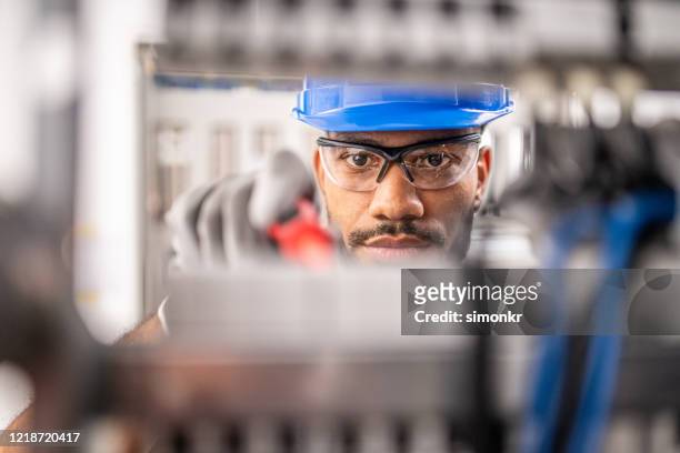 apprentice connecting wires in distribution board - distribution board stock pictures, royalty-free photos & images