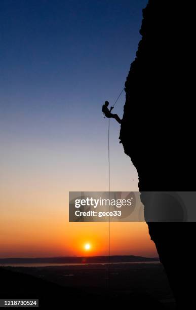 mens die op rots beklimt - overhangend stockfoto's en -beelden