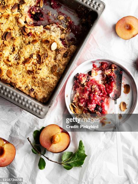 plums crumble pie, crumble, fruit crumble,crumble with plum, crumble with plums and nuts on a white background, sweet - red plum stock pictures, royalty-free photos & images