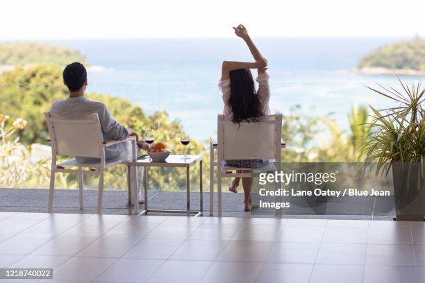 young chinese couple relaxing on balcony - beach house balcony stock pictures, royalty-free photos & images
