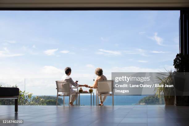 senior chinese couple relaxing on balcony - beach house balcony fotografías e imágenes de stock