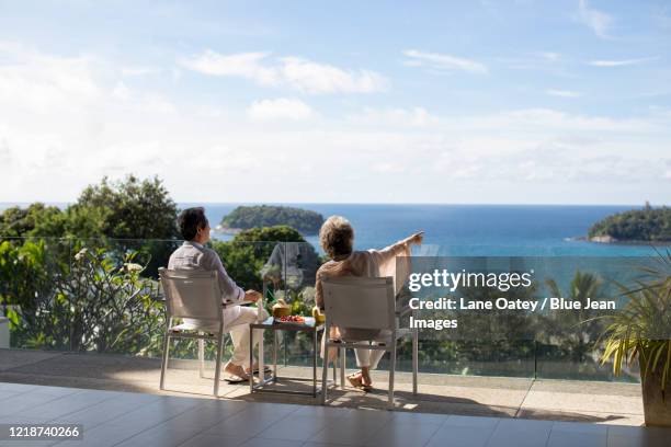 senior chinese couple relaxing on balcony - beach house balcony stock pictures, royalty-free photos & images