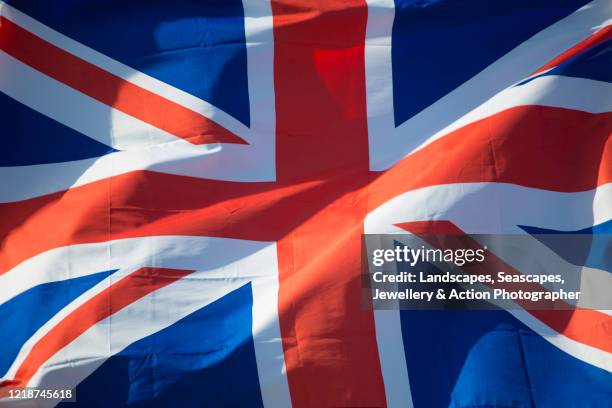 union jack flag fluttering in the wind - bandera del reino unido fotografías e imágenes de stock