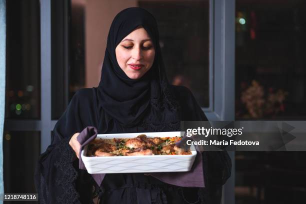 woman is holding a dish for iftar - cucina del medio oriente foto e immagini stock