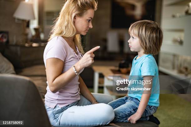 angry single mother scolding her small son at home. - furious child stock pictures, royalty-free photos & images
