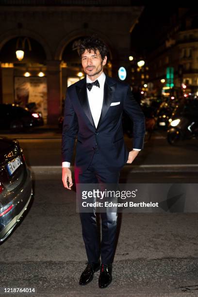 Andres Velencoso Segura wears a white shirt, a bow tie, a navy blue blazer jacket, suit pants, outside the Harper's Bazaar Exhibition as part of the...
