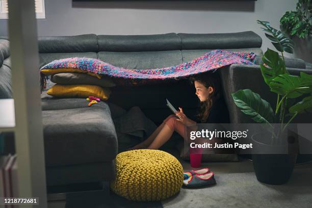 young girl on digital tablet in the safety of her 'den' - holen stockfoto's en -beelden