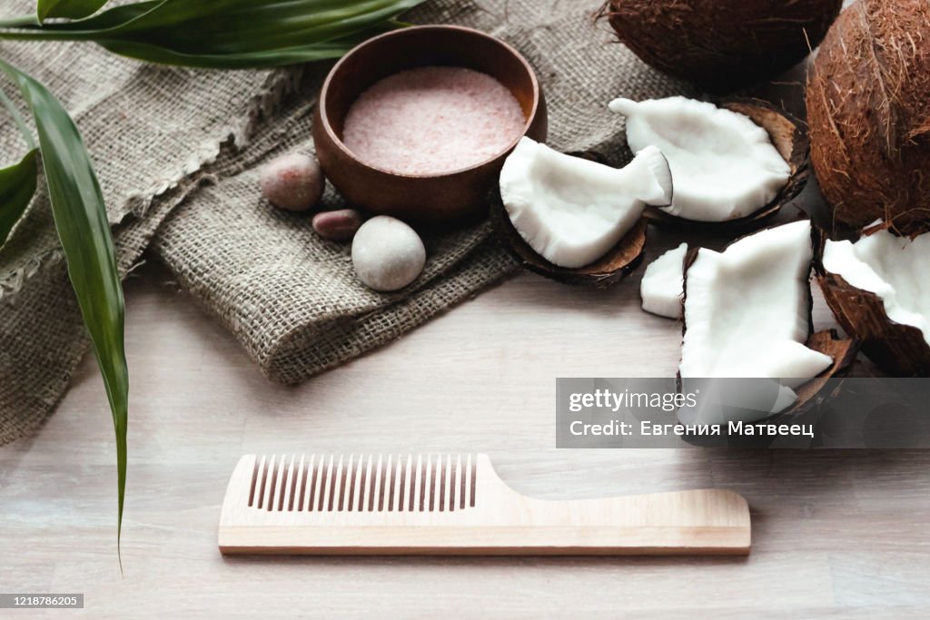 Bath, spa concept, salt, coconut, lighting candle, linen towel, haircomb on wooden background