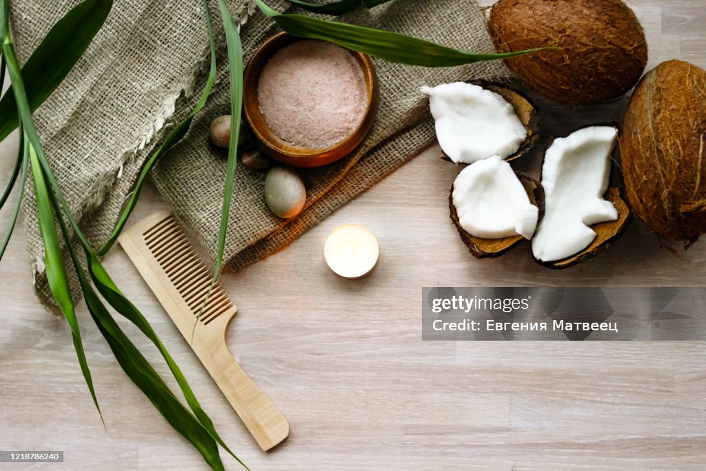 Bath, spa concept, salt, coconut, lighting candle, linen towel, haircomb on wooden background