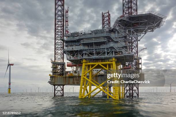 view on offshore wind-farm with 8mw wind-turbines and offshore platform in german north sea with dramatic clouds - north sea wind farm stock pictures, royalty-free photos & images