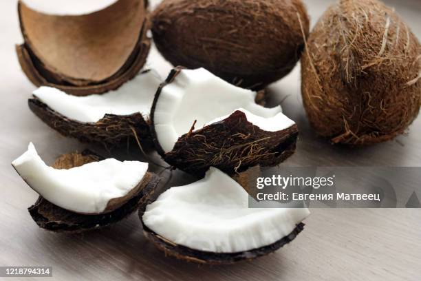 pieces of broken coconut on white wooden table background. close up. selective focus. copy space - coconut chunks stock pictures, royalty-free photos & images