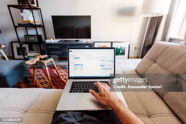 personal perspective point of view of a man working on laptop in the living room at home - persoonlijk perspectief stockfoto's en -beelden