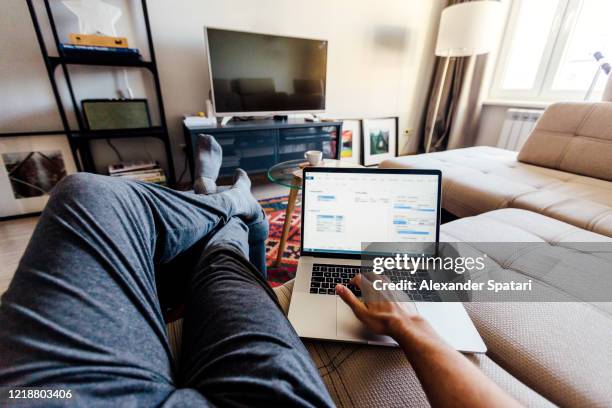 personal perspective point of view of a man working on laptop in the living room at home - laptop couch stock pictures, royalty-free photos & images