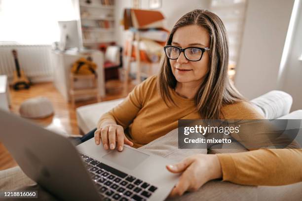 mature woman having online consultation with psychotherapist at home on laptop - virtual reality medical stock pictures, royalty-free photos & images