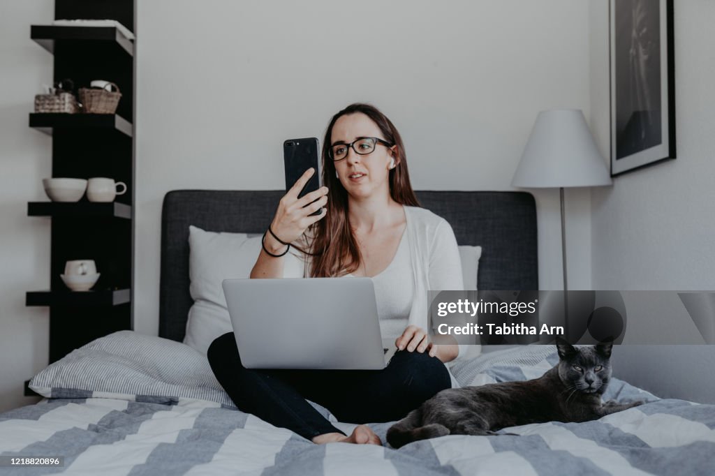 Frau arbeitet von zu Hause im Home Office mit Airpods drahtlosen Bluetooth Kopfhörer Facetime Videotelefonie Skype