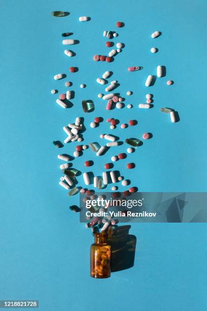 top view of bottle with various pills and tablets on the blue background - antibiotic stock pictures, royalty-free photos & images