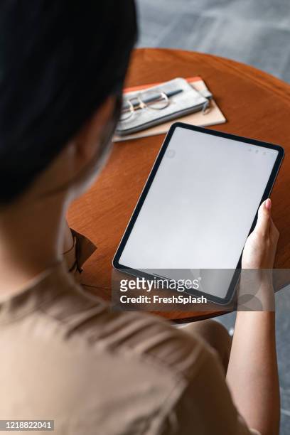 visualizzazione a spalla di un tablet digitale con uno schermo vuoto nelle mani di un'imprenditrice irriconoscibile (spazio di copia) - composizione verticale foto e immagini stock