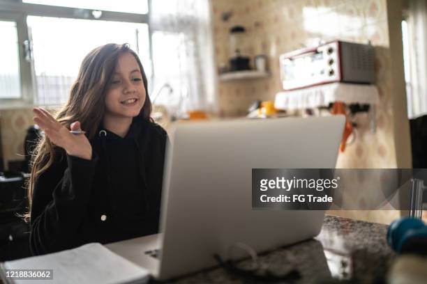 meisje dat en een videovraag via laptop thuis bestudeert en maakt - very young webcam girls stockfoto's en -beelden