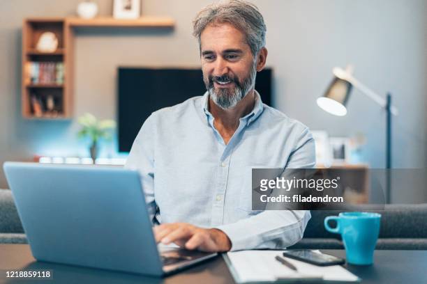 working at home - businessman working on a laptop with a coffee stock pictures, royalty-free photos & images