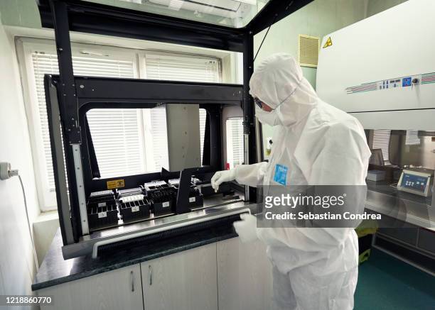 epidemiologist in protective suit, mask and glasses works with patient swabs to detect specific region of 2019-ncov virus causing covid-19 viral pneumonia. sars-cov-2 pcr diagnostics kit concept. - biopsy - fotografias e filmes do acervo