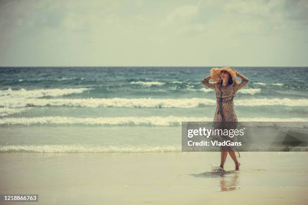 woman walking on the beach - long dress stock pictures, royalty-free photos & images