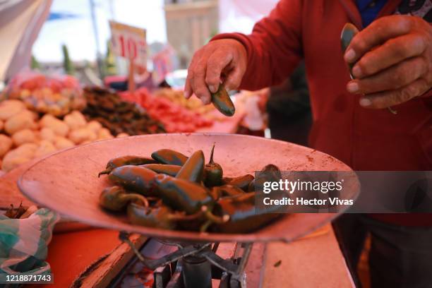 Seller weighs jalapeño peppers to sell on April 14, 2020 in Santa Maria Jajalpa, Mexico. This town of around 6,500 inhabitants in the State of Mexico...