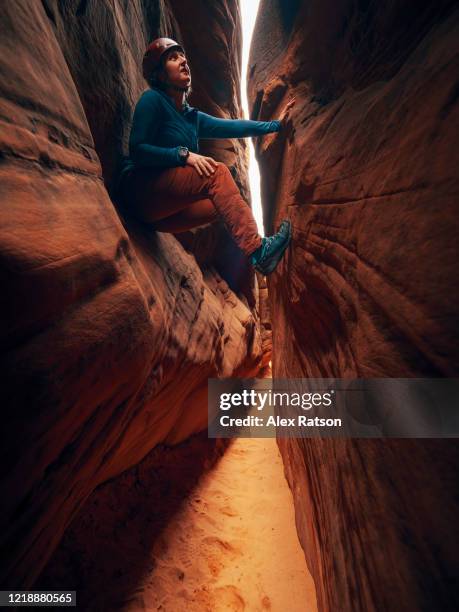 a young women climbs up through slot canyon - canyoning stock pictures, royalty-free photos & images