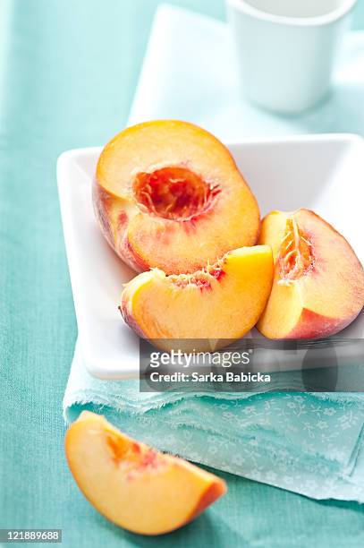 cut peaches on white plate - peach fotografías e imágenes de stock