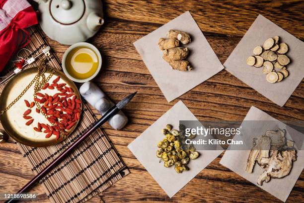 variety of traditional chinese medicine on the wooden desk - astragalus stock-fotos und bilder