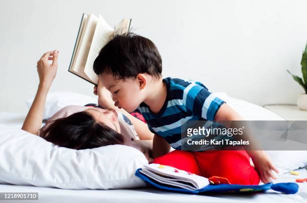 southeast asian mother and son are reading book on the bed - philippines family 個照片及圖片檔