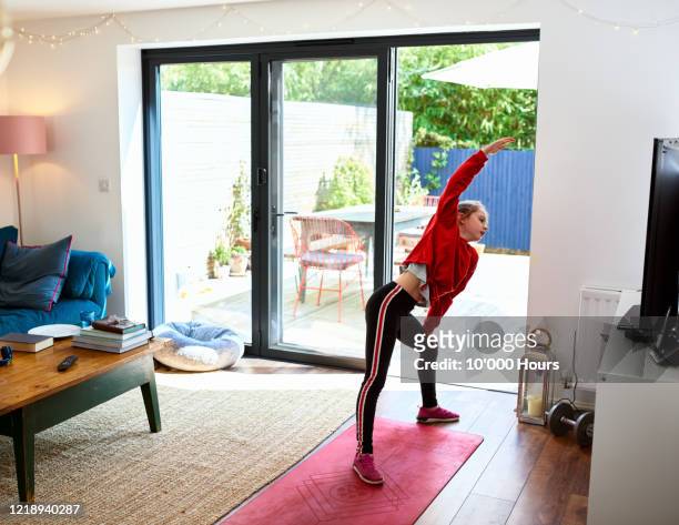 Girl stretching sideways during at home fitness class