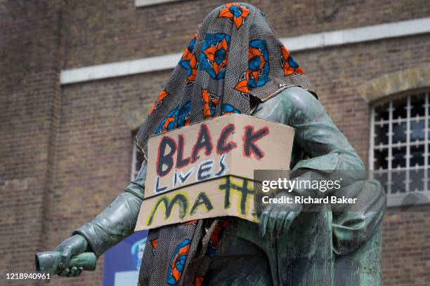 Hours before it was removed by the Canal and River Trust, the statue of merchant slave owner, Robert Milligan stands partially covered by Black Lives...