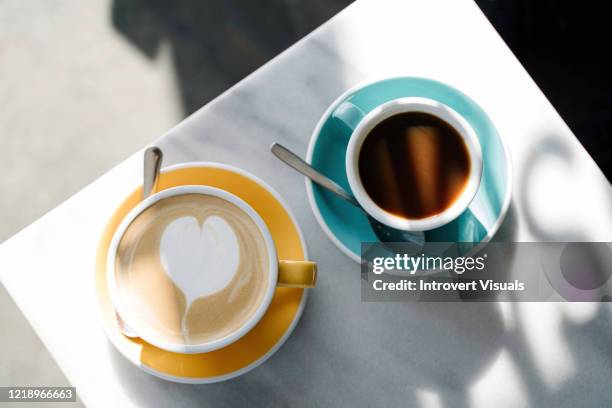 two cups of coffee on the marble table - coffee cups table stock pictures, royalty-free photos & images