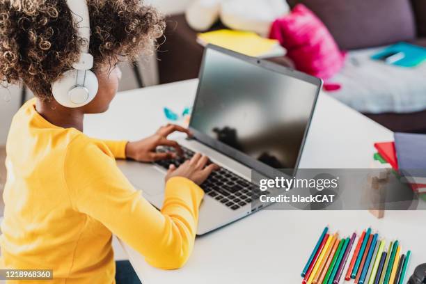 girl at home using laptop - e learning children stock pictures, royalty-free photos & images