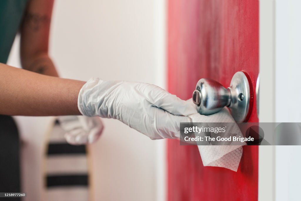 Woman disinfecting door handle