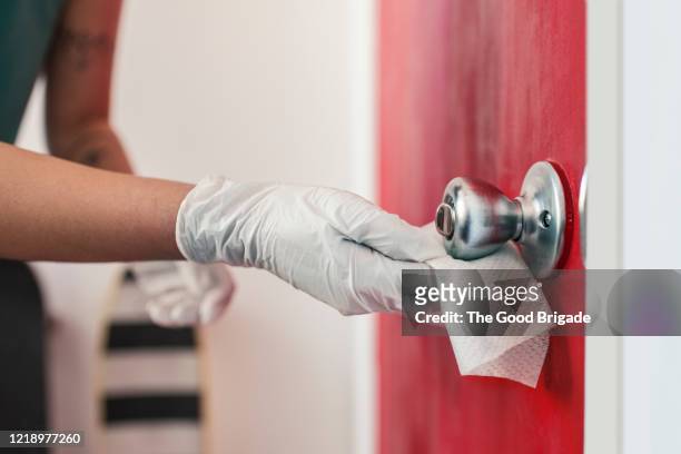 woman disinfecting door handle - rubbing stock pictures, royalty-free photos & images