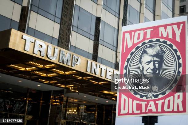 Marcher holds a sign that says, "Not My Dictator" with a picture of Donald Trump in front of Trump International Tower during the Woman's March in...