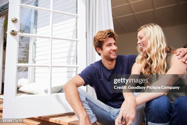 pareja joven sonriente hablando en su patio en el verano - la tarde fotografías e imágenes de stock