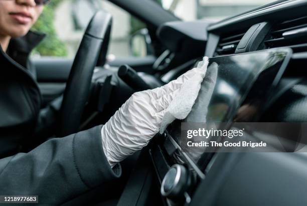 woman cleaning car interior with disinfecting wipe - cleaning inside of car stock pictures, royalty-free photos & images