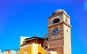 Clock tower of Church Santo Stefano in Capri Island town reflex