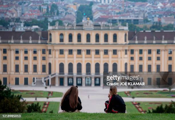 Young women enjoy their picnic in a garden of Schoenbrunn palace, the main summer residence of the Habsburg rulers, on a cloudy late evening in...