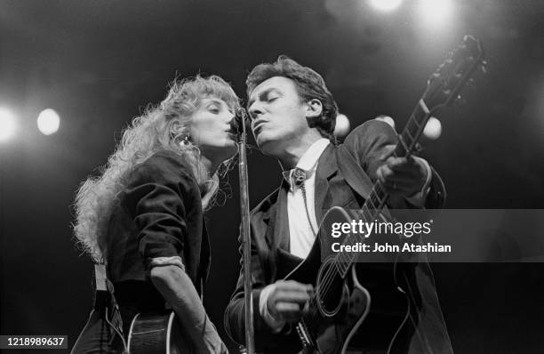 Musician Patti Scialfa and Bruce Springsteen are shown performing on stage during a "live" concert appearance on February 28, 1988.