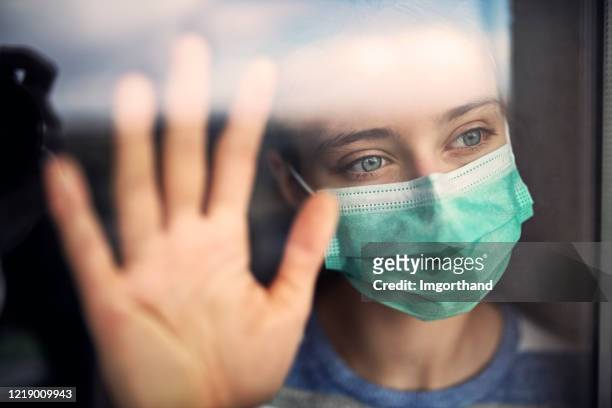 adolescente triste restant à la maison pendant la quarantaine covid-19 - face mask coronavirus photos et images de collection